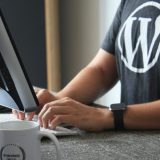 person in black and white t-shirt using computer