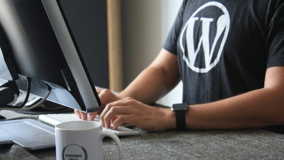 person in black and white t-shirt using computer